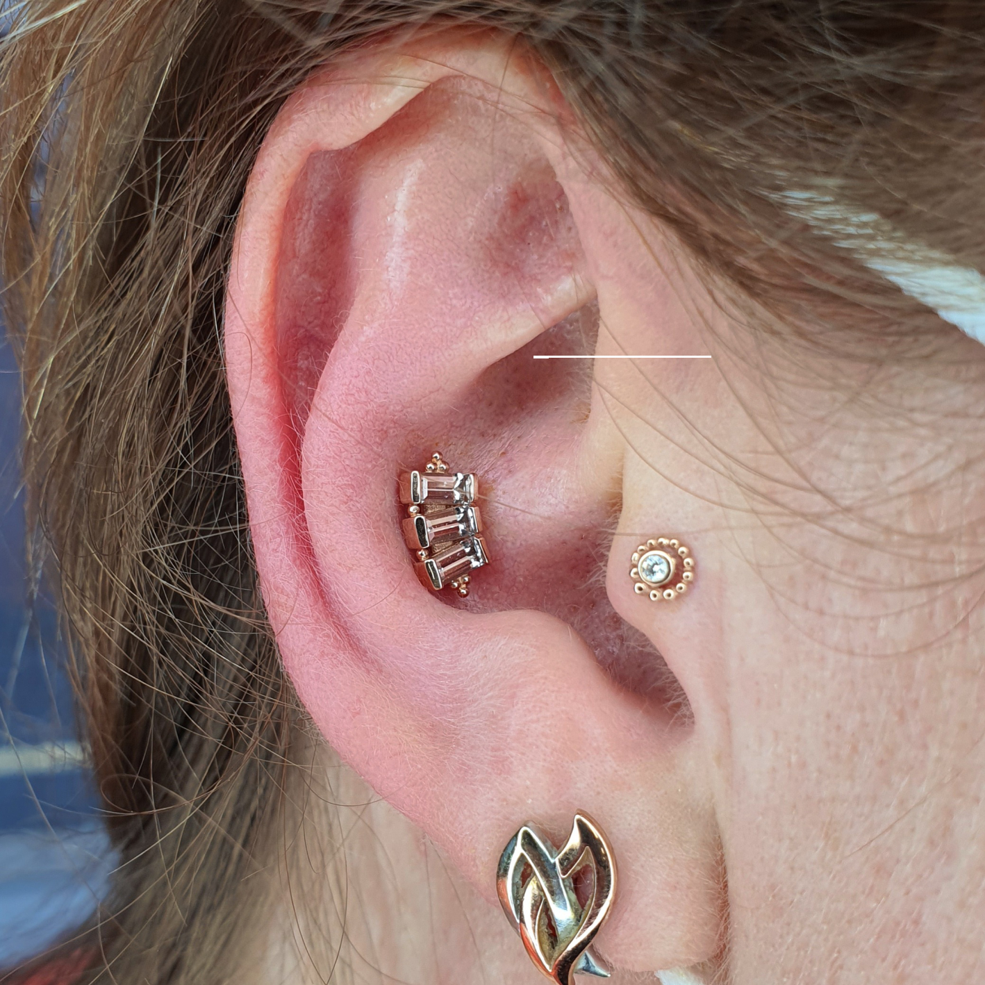 Conch and tragus piercings with solid gold jewellery