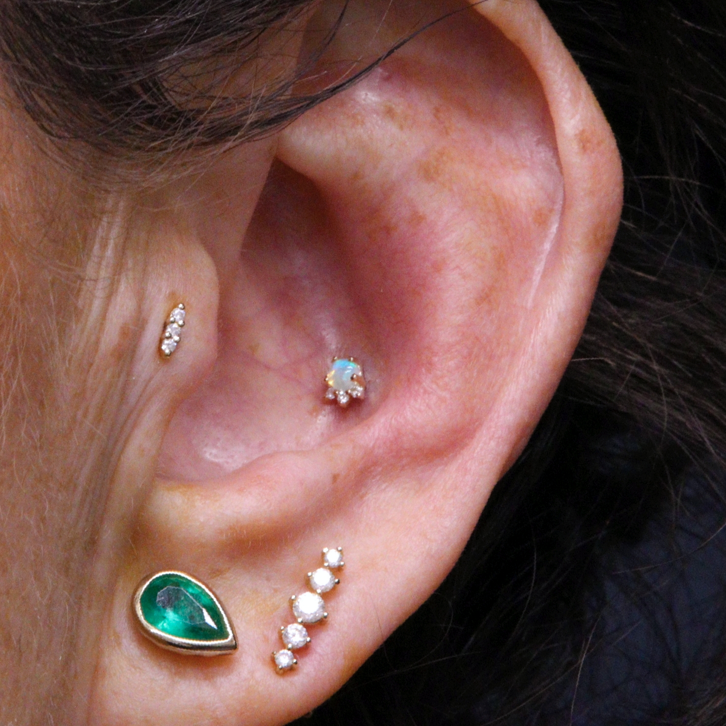 Conch and tragus piercings with solid 14k gold jewellery