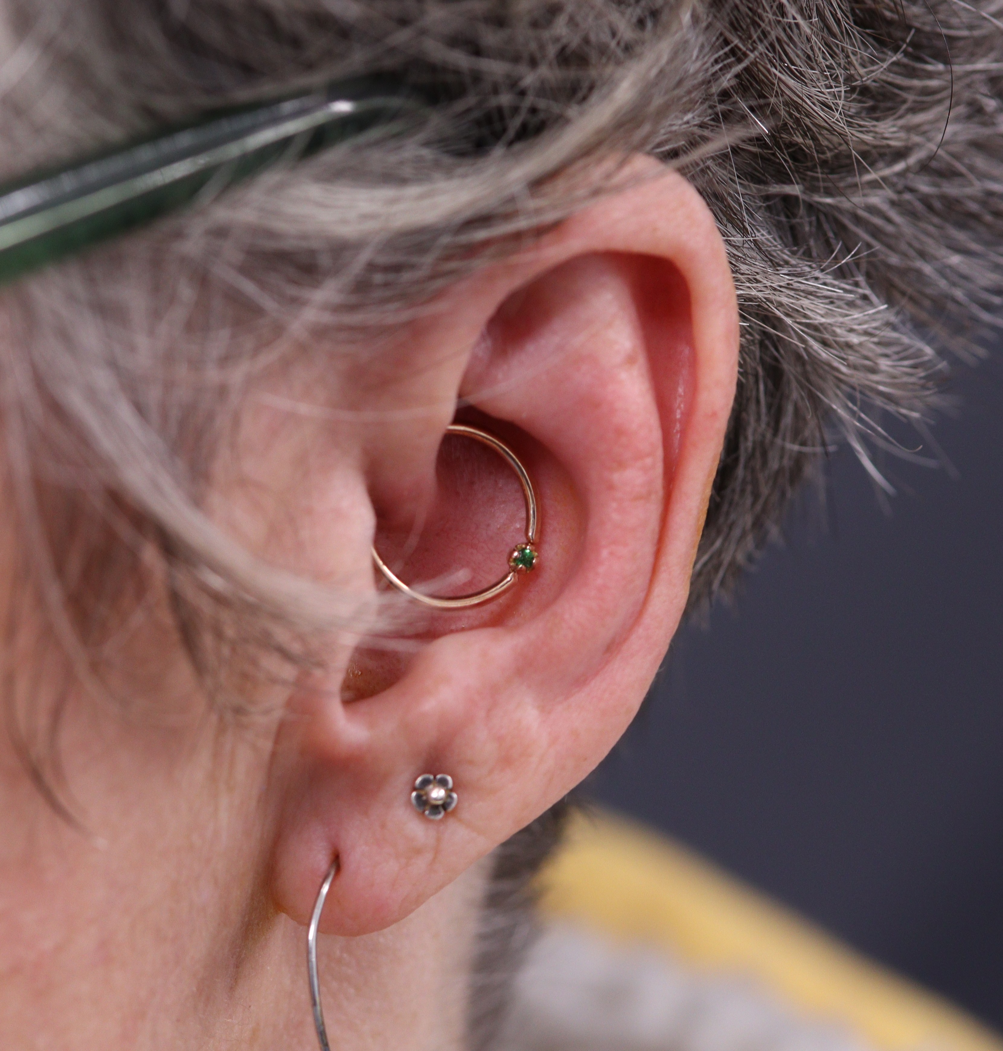 Daith piercing with fixed gem ring in rose gold and tsavorite from Ixus fine jewellery