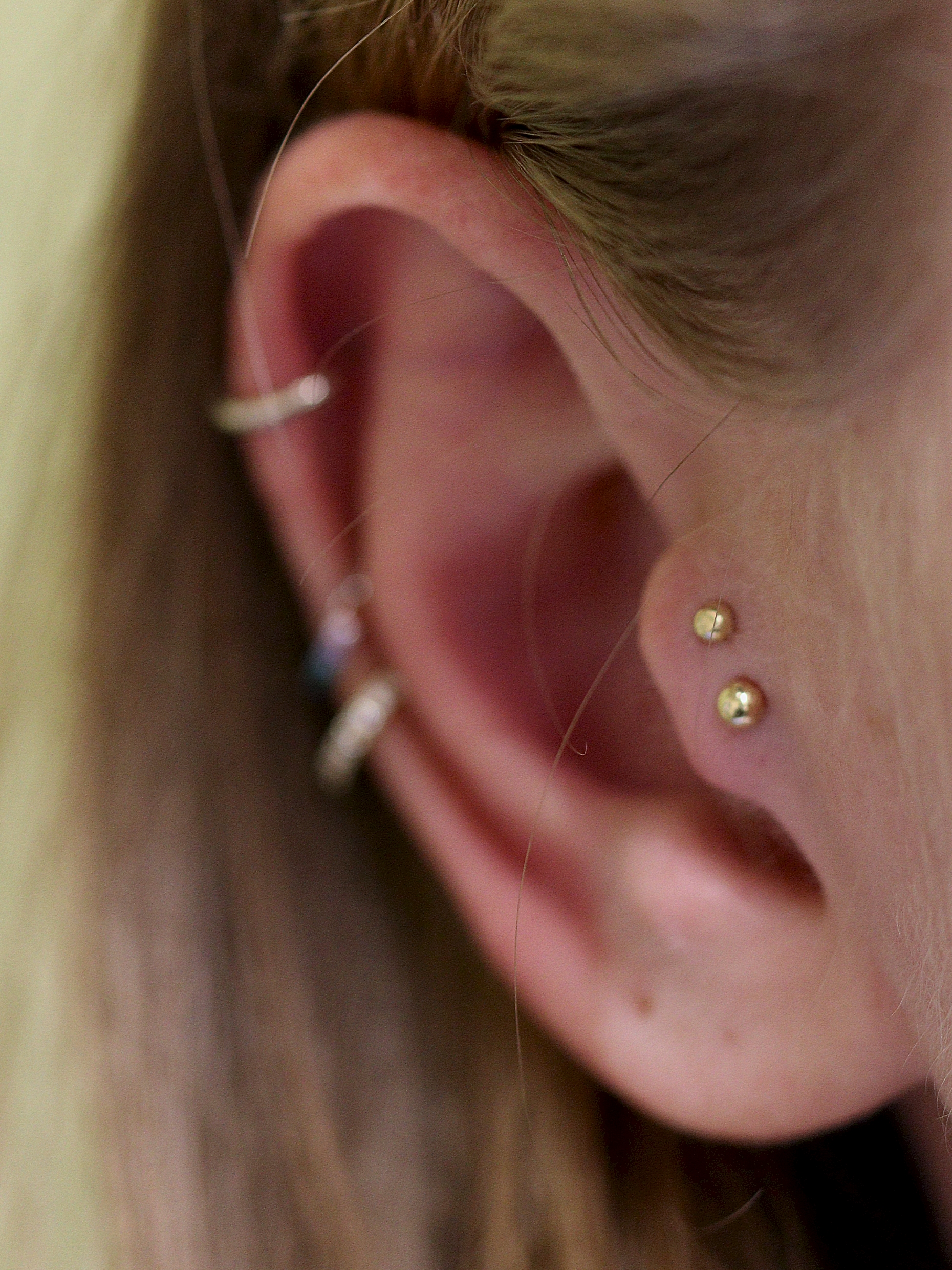 Double tragus piercing with solid 18k Under the Dome ends from Ixus Fine Jewellery