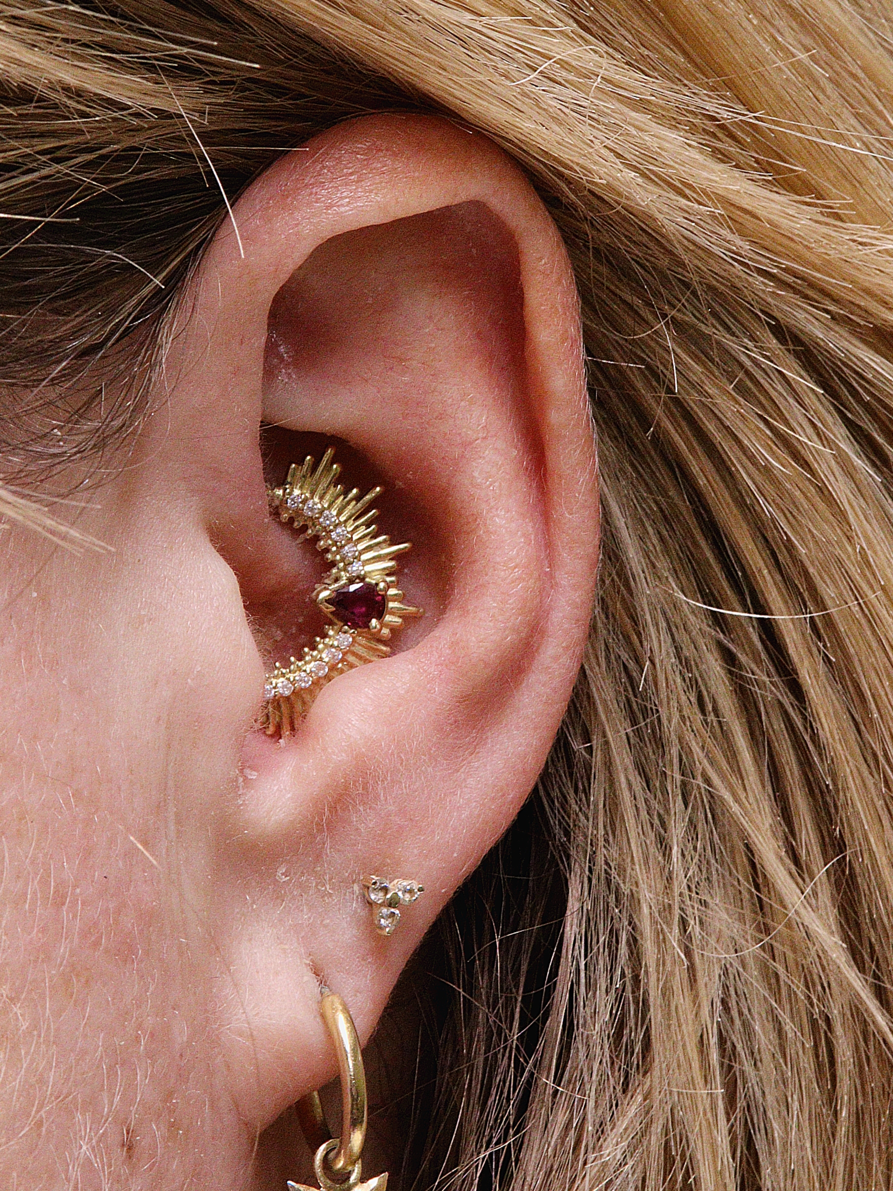 daith piercing with Oddity ring by Ixus fine jewellery in 18k yellow gold with garnet pear and moissanite accents